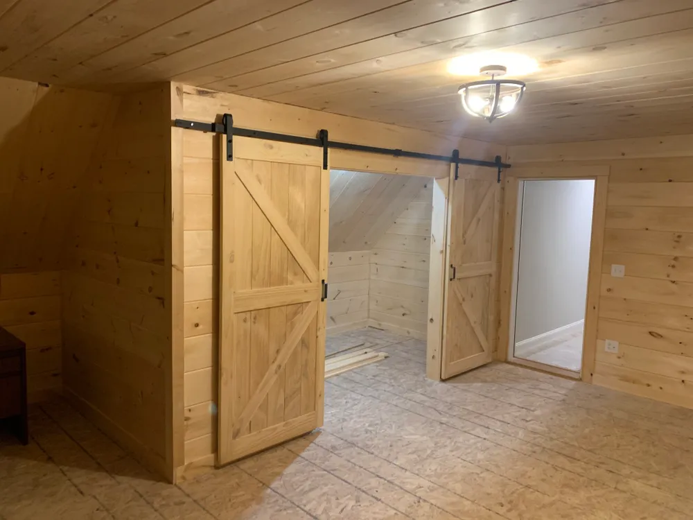 A finished room with sliding barn doors