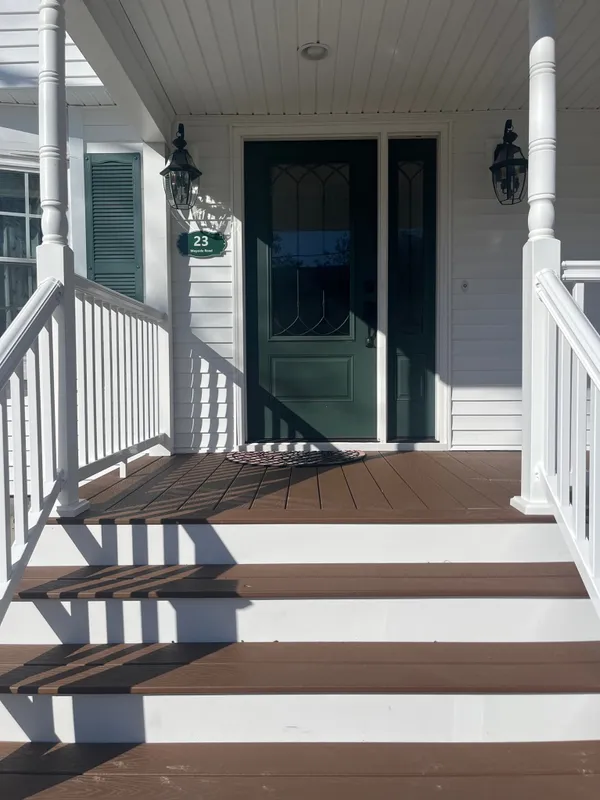 A covered entry with white railings