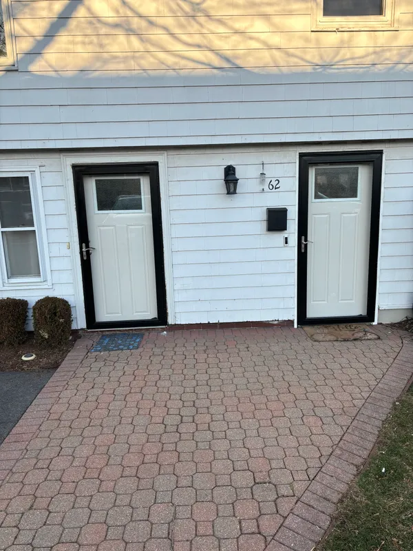 Two new exterior doors set in white siding